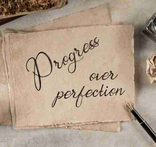 A plack with a pen which states progress over perfection