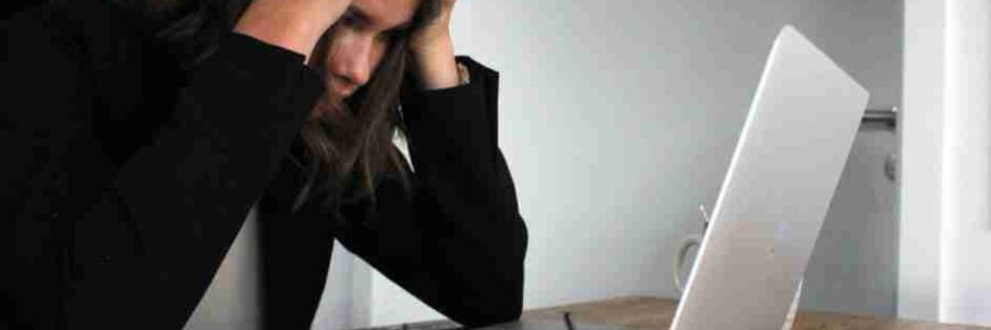 woman in black long sleeve shirt covering her face with her hands