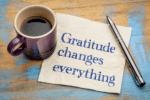 How Gratitude Can Change Your Life -a napkin with a cup of coffee and a pen on a wooden surface