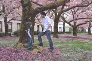 Parenting Father and Son standing at a tree with blooms on the ground